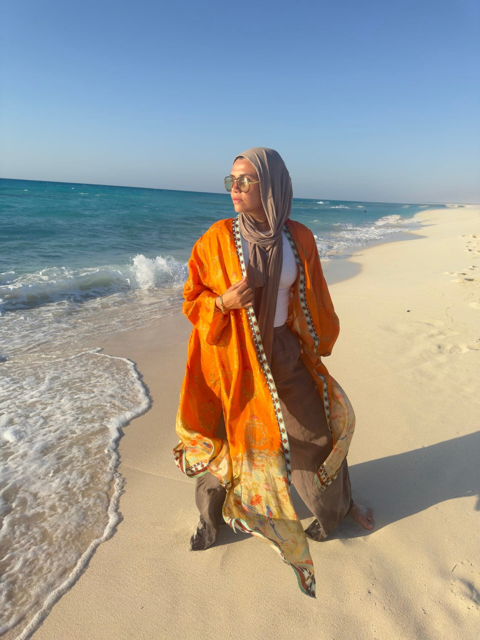 “Orange paisley-inspired kimono with oriental floral accents – perfect for effortless beach elegance.”